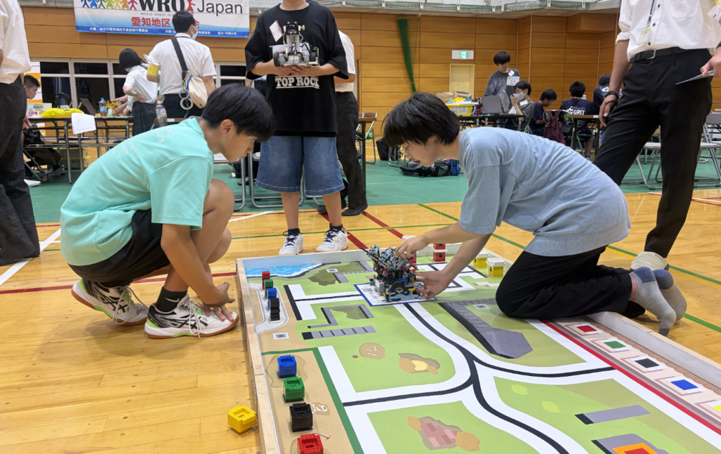 競技コートにロボットを設置する生徒たち